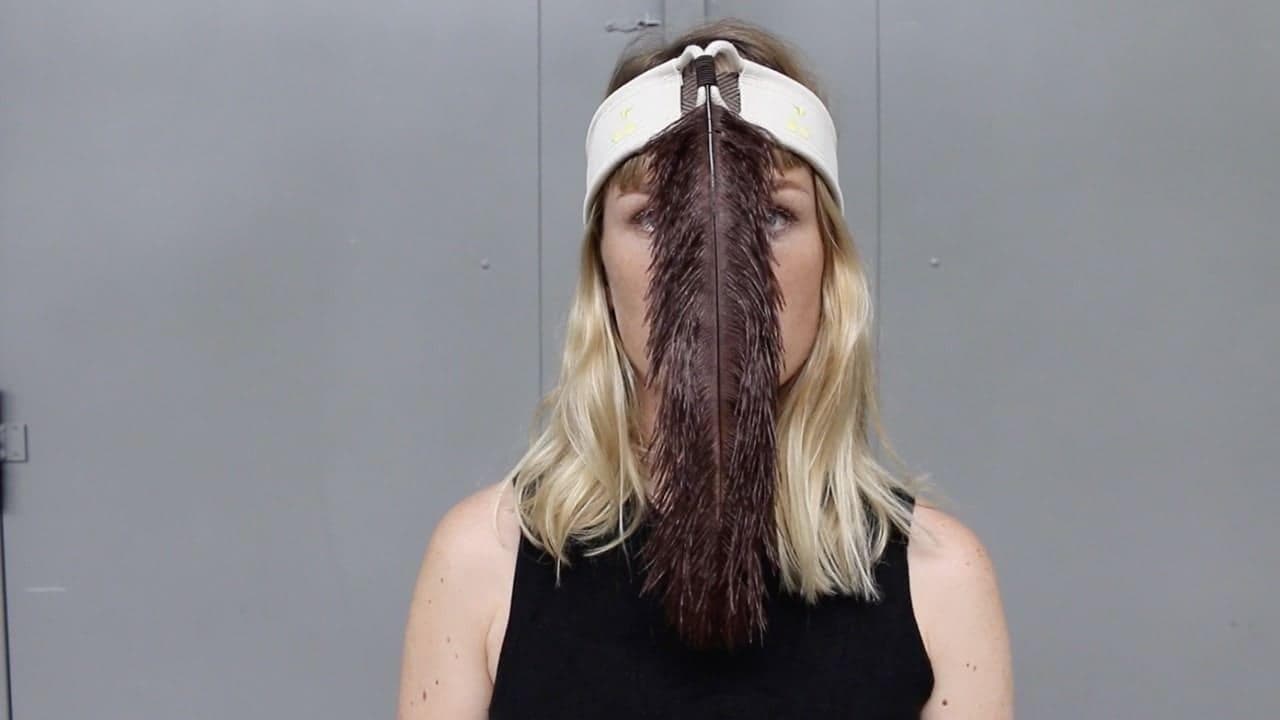 visage vue de face en train de souffler sur une plume